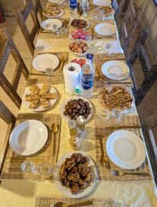 Una mesa larga con platos de comida encima. en Luxury white camp, en Merzouga 13 fotos más