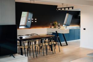 a kitchen with a dining room table and chairs at Vicanto A frame Bucovina in Gura Humorului