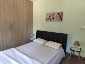 a bedroom with a bed with white sheets and two lamps at Roses Villa in Trimiklini +34 photos