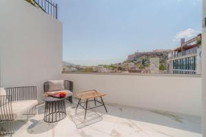 a balcony with chairs and a table and a large window at Eternity Athens in Athens