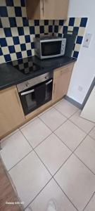 une cuisine avec une cuisinière et un micro-ondes dans l'établissement CP Studio Apartment - Free Wifi City Centre, à Leicester