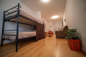 a bedroom with a bunk bed and a living room at Las torres 1 in Calatayud