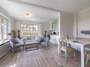 a kitchen and living room with a table and chairs at Leuchtturmblick-West in Kampen