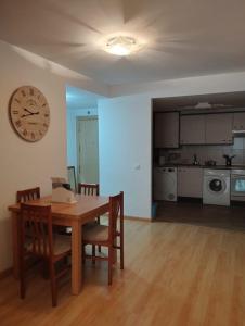 a dining room with a table and a clock on the wall at Las torres 1 in Calatayud +21 photos