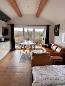 a living room with a couch and a table at The Stables at Lower Carr Barn in Halifax