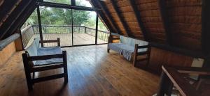 a room with two chairs and a balcony with windows at Daisy Lodge in Barberton