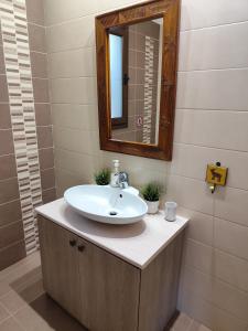 a bathroom with a sink and a mirror at Roses Villa in Trimiklini