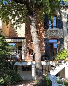 ランスにあるMaison meulière du 34e Sacre, à proximité du Domaine Pommeryの木とバルコニーのある建物