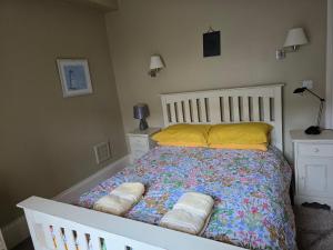 a bed with pillows on it in a bedroom at Seaview Apartment in Aberystwyth