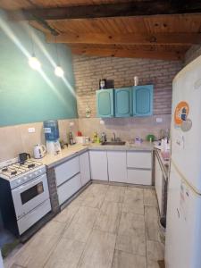 una cucina con elettrodomestici bianchi e armadietti blu di La Alpina a Chivilcoy