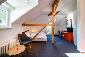 a bedroom with a loft bed and a table and chairs at B&B Villa Hotel in Mariánské Lázně