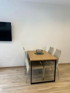 a dining room table with chairs and a flat screen tv at Apartamento MAR Y TERRA in Benajarafe