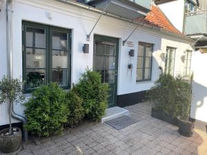 a white house with a green door and some plants at Ferielejlighed IRIS in Sønderborg