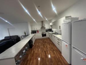 ダービーにあるRoom in centre of Derbyの白い家電製品と木製の床を備えた広いキッチン