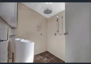 a white bathroom with a shower and a sink at Scarborough Stays - Sleeps 8 by the Beachside in Scarborough +3 photos