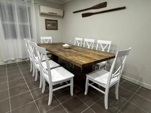 a dining room with a wooden table and white chairs at Scarborough Stays - Sleeps 8 by the Beachside in Scarborough