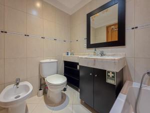 a bathroom with a toilet and a sink and a mirror at Ocean View Machico in Machico +9 photos