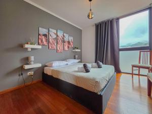 a bedroom with a bed and a large window at Ocean View Machico in Machico