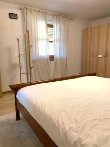 a bedroom with a large white bed and a window at spacious furnished apartment in Markt Erlbach
