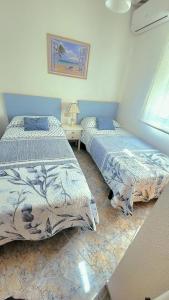 a bedroom with two beds and a table with a lamp at Apartamento muy cerca del mar. in Arenales del Sol +19 photos