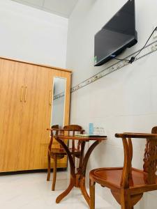 Nhà Nghỉ 79 : غرفة مع طاولة وتلفزيون على الحائط