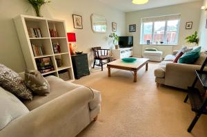 Una sala de estar con dos sofás y una mesa de café. en New Forest home - 4-beds and garden - 10 mins from Beach, en Hordle