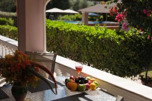 Un plato de fruta en una mesa con una copa de vino. en FAMILY SWEET HOME IOANNA, en Karousádes 32 fotos más