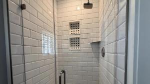 une salle de bain avec douche aux murs carrelés blancs dans l'établissement Windsor Escape, à Cape May 32 autres photos