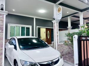 a white car parked in front of a house at I'm Home Narathiwat in Narathiwat