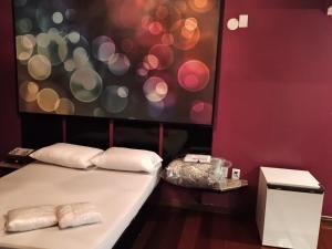 Dos camas en una habitación con una pared roja. en Motel Antares, en Porto Alegre