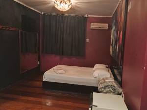 Habitación pequeña con cama y lámpara de araña. en Motel Antares, en Porto Alegre