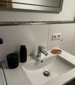un lavabo blanc dans une salle de bain avec un miroir dans l'établissement Ferienwohnung vor dem Zoller, à Boll 26 autres photos
