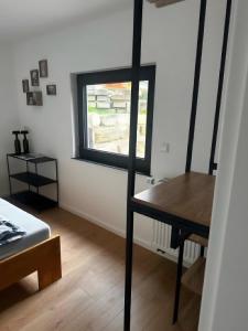 Cette chambre comprend une table et une fenêtre. dans l'établissement Ferienwohnung vor dem Zoller, à Boll