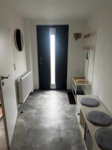 un couloir avec une porte bleue et une pièce avec des lavabos dans l'établissement Ferienwohnung vor dem Zoller, à Boll