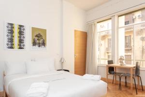 a bedroom with two beds and a desk and a window at grey l studio apartments Downtown Cairo Ouzonian House in Cairo