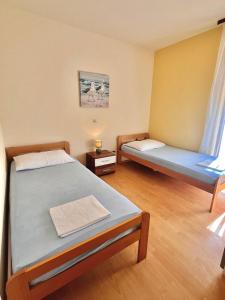 a room with two beds and a window at Apartmani Fani in Banjol