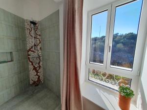 a bathroom with a shower and a window at Molí d'en Salom in Sant Climent Sescebes
