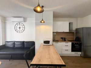 eine Küche und ein Wohnzimmer mit einem Tisch und einer Mikrowelle in der Unterkunft M001 Marquer Agréable T2 centre ville in Annemasse