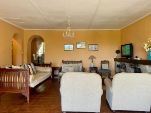Victorian style cottage in Nyanga - 2096 في Juliasdale: غرفة معيشة مع كرسيين وأريكة