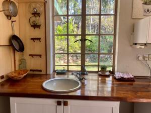 Victorian style cottage in Nyanga - 2096 في Juliasdale: طاولة مطبخ مع حوض ونافذة +38 صورة
