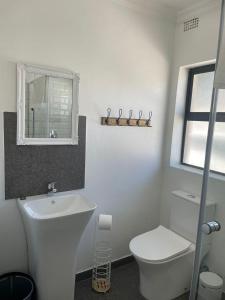 a white bathroom with a toilet and a sink at Canvas Lofts 1 – Famona modern 2-bed - 2310 in Bulawayo +12 photos