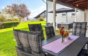 a wooden table with chairs and a vase of flowers at 2 Bedroom Cozy Home In Salopeki Modruski in Modruš +23 photos