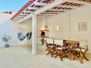 a dining room with a wooden table and chairs at Pijamas House 2 in Gafanha da Encarnação