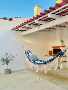 a hammock hanging on the side of a house at Pijamas House 2 in Gafanha da Encarnação +14 photos