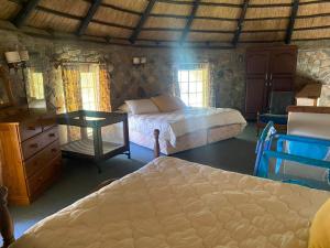 Beautiful round shaped cottage - 2094 في Juliasdale: غرفة نوم بسريرين وطاولة ونوافذ