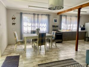 Stunning private cottage in the heart of Nyanga - 2095 في Juliasdale: غرفة طعام مع طاولة بيضاء وكراسي