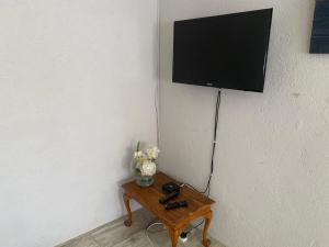 Stunning private cottage in the heart of Nyanga - 2095 في Juliasdale: تلفزيون معلق على جدار مع طاولة