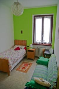 a bedroom with a couch and a bed and a window at B&B I Cherubini in Cislago