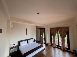 タンガラにあるMowni View - Tangalleの大きなベッドと大きな窓のある寝室