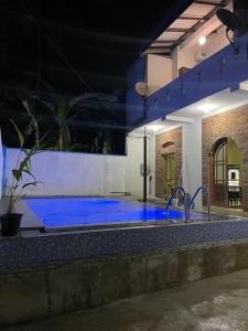 a swimming pool at night with a blue pool at FEEL Beach Apartments in Kalutara